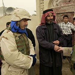 A Civil Affairs soldier greets a local imam at the grand opening of a medical center in Baghdad, Iraq, January 2004.