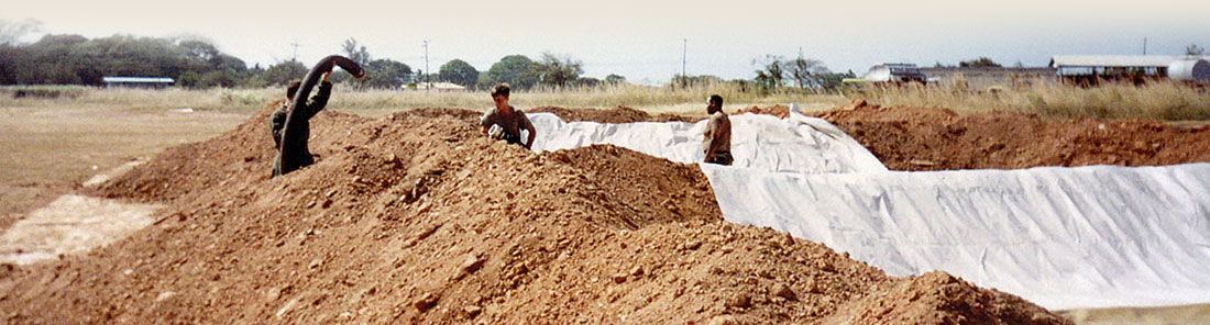 Soldiers connect 4-inch hoses to the 10,000 gallon collapsible fuel bags. The bags are emplaced with the help of U.S. Army Engineers, who build protective berms around the site.