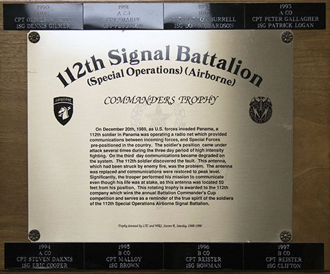 The inscription on the base of the 112th Signal Battalion Commander’s Trophy describes the situation at the time it was damaged. The names of Company Commander and First Sergeant from each year’s winning company line the top and bottom of the base.