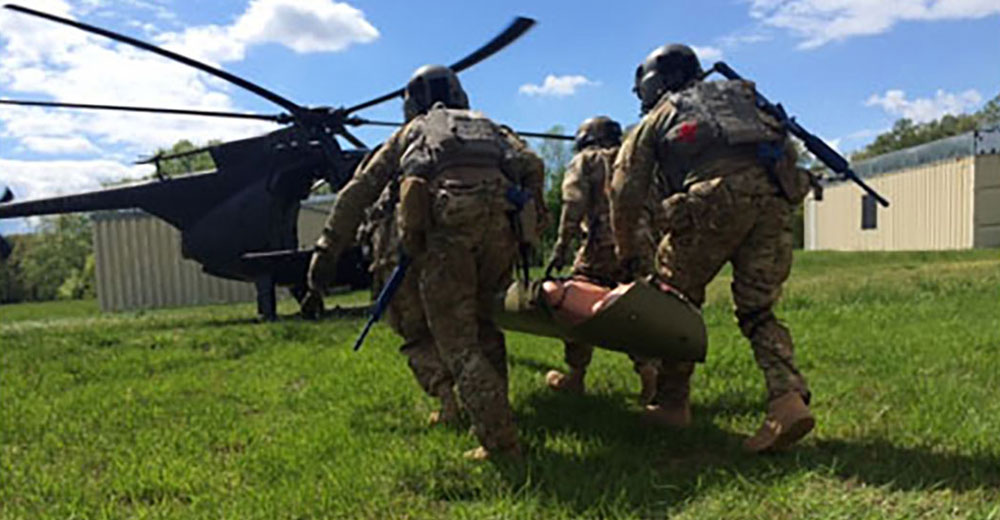 Students move their simulated casualty toward an MH-6 Little Bird for evacuation during the Special Operations Aviation Medical Indoctrination Course (SOAMIC) provided by Company B, SOATB.