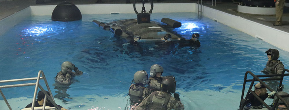 After completing the Combat Skills course, aviation personnel take dunker training at the Allison Aquatics Training Facility to learn how to egress from a helicopter downed in water.  