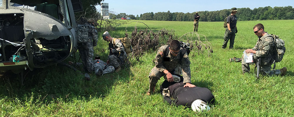 Trainees treat simulated casualties at a mock crash site during the First Responder phase of Combat Skills, Company A, SOATB. 