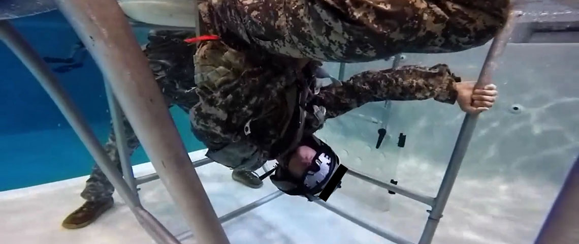 A 160th SOAR aviator candidate releases his seat straps during dunker training at the Allison Aquatics Training Facility, Fort Campbell, KY.