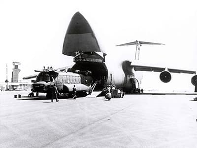 The first of two Chinooks loading onto the C-50 for transport to Chad. The nose of the airplane pivots upward to allow access to the cargo bay.