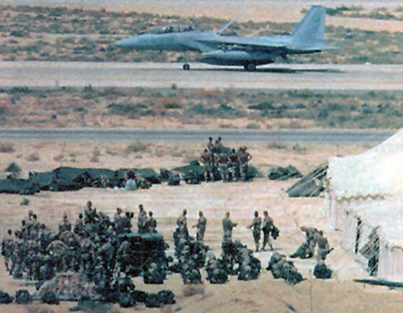 A Royal Saudi Air Force F-15 taxis past American soldiers just arrived in Saudi Arabia, August 1990.