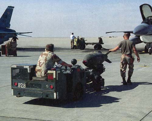 A ground crew prepares to load a leaflet bomb onto an F-16 in Dammam, Saudi Arabia.