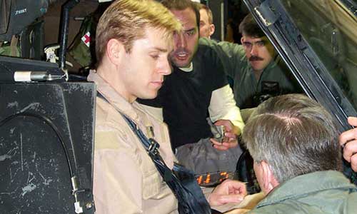 Actors Ron Eldard and Jeremy Piven, who played pilots of the two downed Black Hawks in the film, sit in an MH-60 cockpit while visiting the 160th SOAR at Fort Campbell.