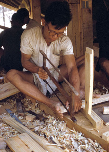 After the Tet Offensive, the 41st CA Teams worked to improve the economic situation of the many Vietnamese that came to the refugee camps. This carpenter uses wood from packing and ammunition crates to make furniture.
