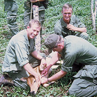 Another project for the 41st teams was to provide veterinary care. SP5 Ron E. Matheson holds a calf down while another 41st CA member gives it an injection.