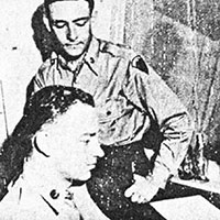 Tape recordings of intercepted broadcasts then went for translation.  An enlisted Russian linguist (front) translates Soviet broadcasts while 1LT Roy W. Nickerson waits to have his Romanian tape translated.