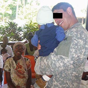 CPT Vick Cider holds a child at the Haitian Health Fund ‘Center of Hope’ facility in Jérémie.
