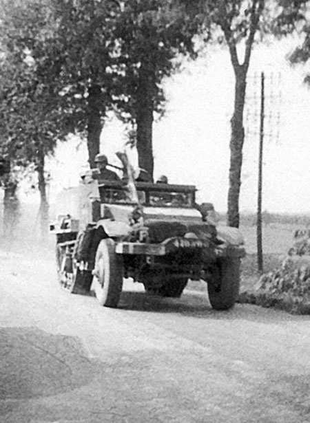 A halftrack from a French armored division passes OG troops near Dijon. With the arrival of the French conventional forces, the OSS mission was over.
