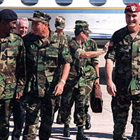 U.S. Ambassador to Haiti William L. Swing (behind Miller’s right shoulder) and the Commanding General, XVIII Airborne Corps and JTF-180, LTG Henry H. Shelton (right)