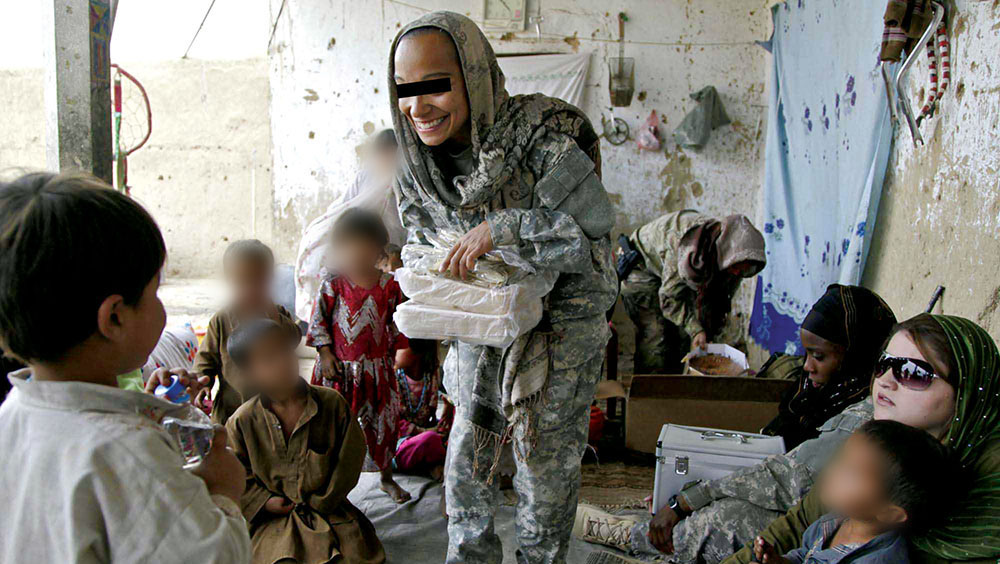 A CST-1 soldier hands out cooking supplies during a women's shura in the village of Oshay, Uruzgan province, Afghanistan, 4 May 2011.