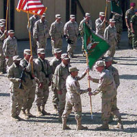 Change of command/transfer of authority (TOA) between the outgoing CJSOTF-A/3rd SFG commander, COL Mark V. Phelan, and the incoming commander, COL Joseph D. Celeski, at ‘Camp Abel,’ Bagram, on 28 May 2002.  COL Celeski (L) receives the 3rd SFG (A) flag from MG Geoffrey C. Lambert, commander of the U.S. Army Special Forces Command (USASFC).
