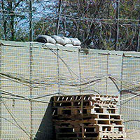 An expedient ‘step-up’ fighting position prepared behind a HESCO exterior wall in the CJSOTF camp at Bagram Airbase.  The pallets allowed soldiers to engage enemy outside the perimeter wall behind sandbag protection.  Several of these augmentation fighting positions were sited inside the camp area to cover critical parts of the perimeter.