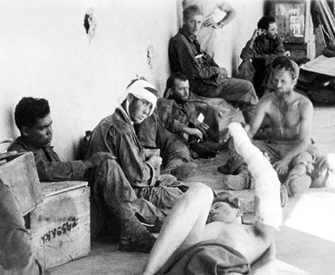 American prisoners of war who were recently liberated from the Cabanatuan prison camp by the 6th Ranger Battalion wait on the porch of an aid station for transfer to a base hospital.