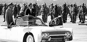 President Kennedy ‘trooped the line’ of paratroopers with Lieutenant General (LTG) Thomas J.H. Trapnell, the Third U.S. Army commander, from his ‘signature’ Lincoln <i>Continental</i> convertible.