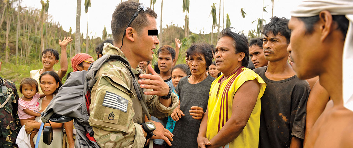 An NCO from Company A, 4-1st SFG talks with residents during a humanitarian relief mission in the Philippines after Typhoon Haiyan in November 2013.