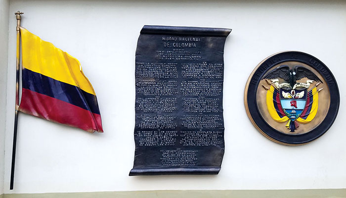 The Colombian flag, National Anthem, and emblem are prominently displayed as a conspicuous reminder of COLAR national focus.