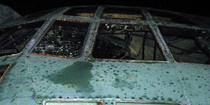 Shattered windshields and glass on left side of the aircraft fuselage