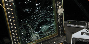 Bullet impacts on windshields on left side of the aircraft fuselage