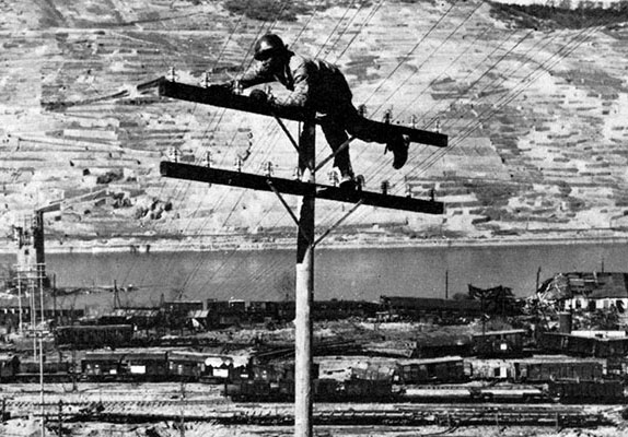 Lineman atop a telephone pole