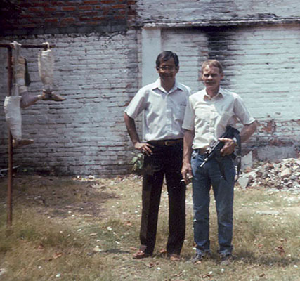 Jim Cloud and chief Salvadoran prosthesis technician in the patio of the shop with the “tree of death” behind them to the left.