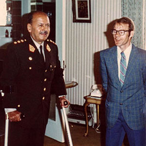 General Juan Velasco Alvarado, President of Peru, standing with Canadian arm crutches next to Jim Cloud before receiving his new prosthesis.