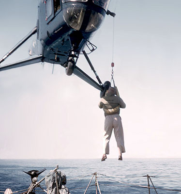 U.S. Navy RH-5 Sikorsky helicopter effecting pilot rescue with sling and “horse collar.”