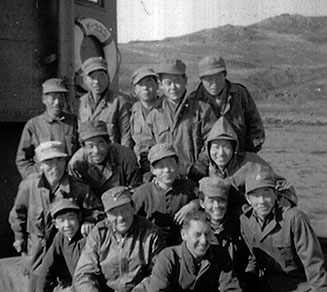Lieutenant Tom Curtis (left front wearing an OG bomber jacket, soft cap, and low quarters) and Sergeant First Class Walter Hoffman (hatless center front wearing an army knit sweater) with Korean crew aboard K-333.