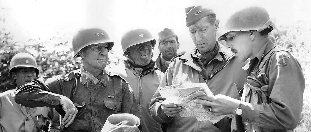 Brigadier General Robert Frederick, Lieutenant General Mark Clark,  Brigadier General Donald Brann, and Major General Geoffrey Keyes study a map on the outskirts of Rome early on the morning of 4 June 1944.