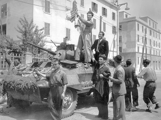 Jubilant Romans flashing the “V” for “Victory” sign. The photo shows the M-8 “Greyhound” armored car. Radcliffe had two assigned to his patrol.