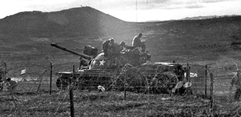 Pleiku radio site perimeter activity. The M48 tank had broken down on the road passing the compound. Both ARVN and US units patrolled the Pleiku area around the radio station. Also visible is a section of the barbed-wire fence around the site.