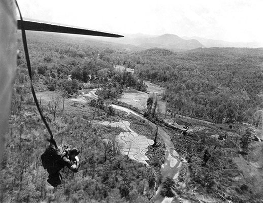 Parachute insertions into Japanese-occupied Burma were often conducted under less-than-ideal conditions. This undated photograph shows a daylight insertion. Note the rough terrain, vegetation, and low altitude of the C-47 drop aircraft.
