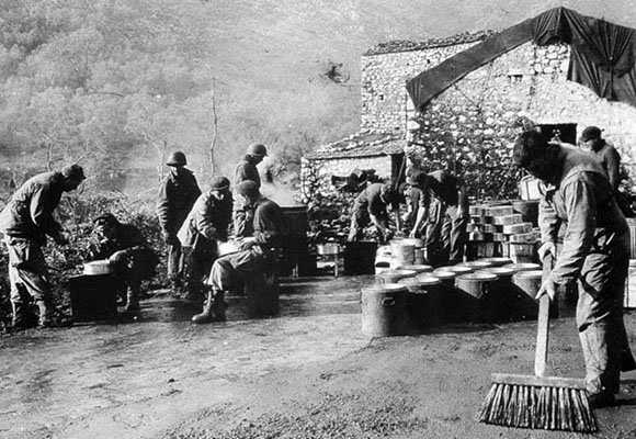 Service Battalion personnel man a field kitchen in the mountains of Italy.