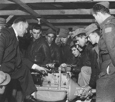A representative from the Studebaker Corporation gives maintenance instruction to American and Canadian Service Battalion personnel on the T-24 Weasel.