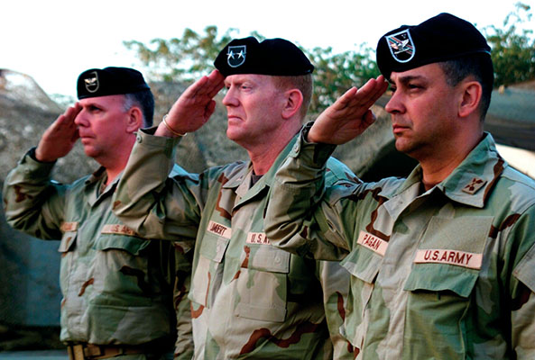 Outgoing commander Colonel John F. Mulholland Jr., Major General Geoffrey C. Lambert, and incoming commander Colonel Hector E. Pagan salute the colors during the change-of-command ceremony in Baghdad. Pagan assumed command of both 5th SFG and CJSOTF-AP on 24 June 2003.