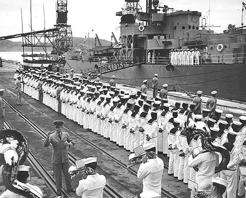 While a U.S. Navy band plays, the Colombian crew is assembled before boarding their new ship, the frigate Almirante Brión, the former USS Burlington, at Yokosuka Naval Base, Japan, on 26 June 1953.