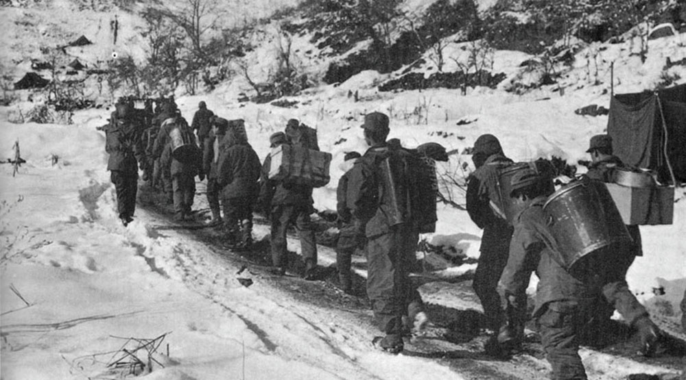 Unarmed Korean Service Corps personnel carrying hot food to the Combat Outpost Line.