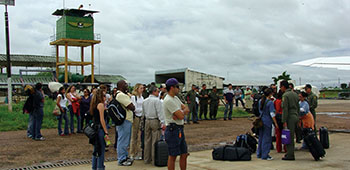 Colombian volunteers and U.S. Civil Affairs arrive at the National Police base in San José del Guaviare. The safest and most economical way to travel in much of Colombia is by air. In the center of the photograph is a reminder of the danger in the area; the control tower also serves as a guard post for the base.