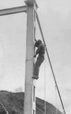 A Lancero instructor climbing a bridge girder to demonstrate the “High Jump” confidence test.