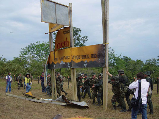 Colombian police and military tearing down a FARC despeje welcome sign.