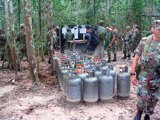 Colombian soldiers inspect an open air FARC IED classroom. The propane cylinders are used to make IEDs.