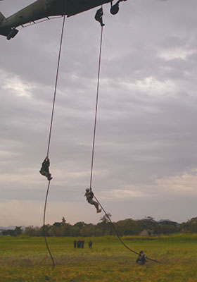 Soldiers descending on Fast Ropes. Multiple soldiers can descend on the same rope, unlike rappelling where only one per line can infiltrate.