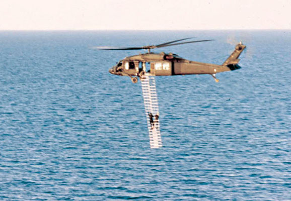 Training with the 7th Special Forces Group over Lake Huron, Michigan, using the troop ladder method of ascending to the helicopter.