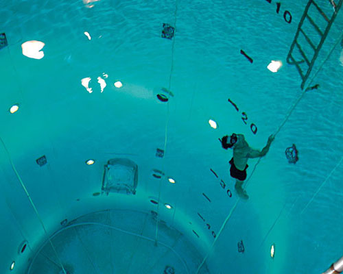 Swimmer completes the free ascent exercise in the fifty-foot tower. This event is essential for learning to return to the surface from deep water.