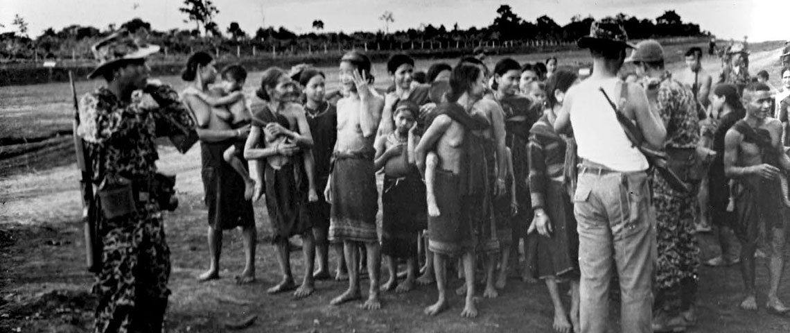 Montagnard refugees fleeing the VC outside the gate at Buon Brieng. They were temporarily housed in tents until a new village site could be arranged and built.