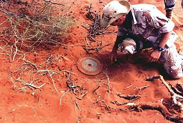 Sergeant First Class Alan Beuscher, ODA 562, uncovering a Russian TM46 Mine during SF demining operations.