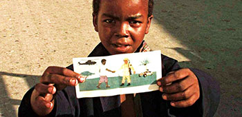 Somali boy holds leaflet from UNITAF PSYOP Campaign.